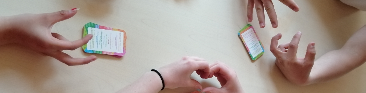 Käsiä tekemässä sormisydämiä ja pelikortteja